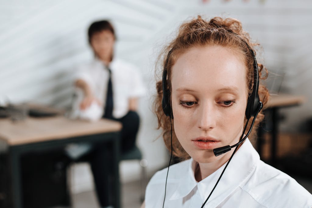 Customer service agent using headset in a modern office environment, focused on her task.